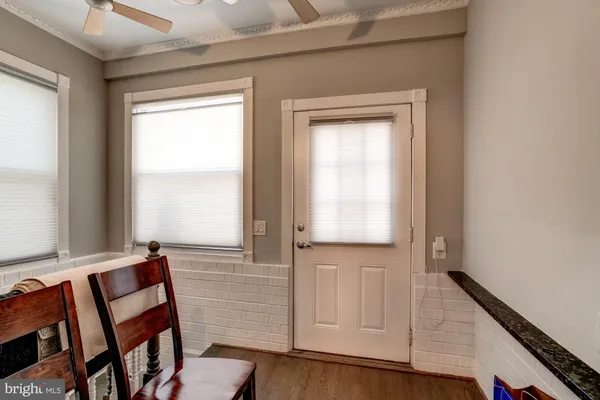 a view of front door with chair and wooden floor
