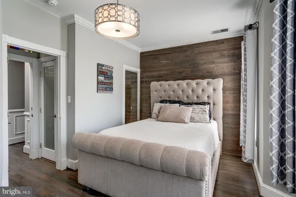 a bedroom with a large bed and a chandelier