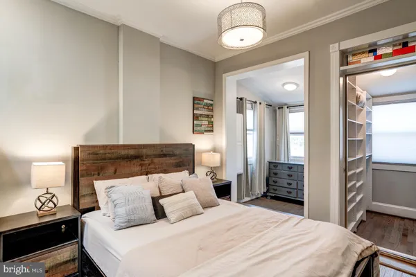 a bedroom with a bed and a refrigerator