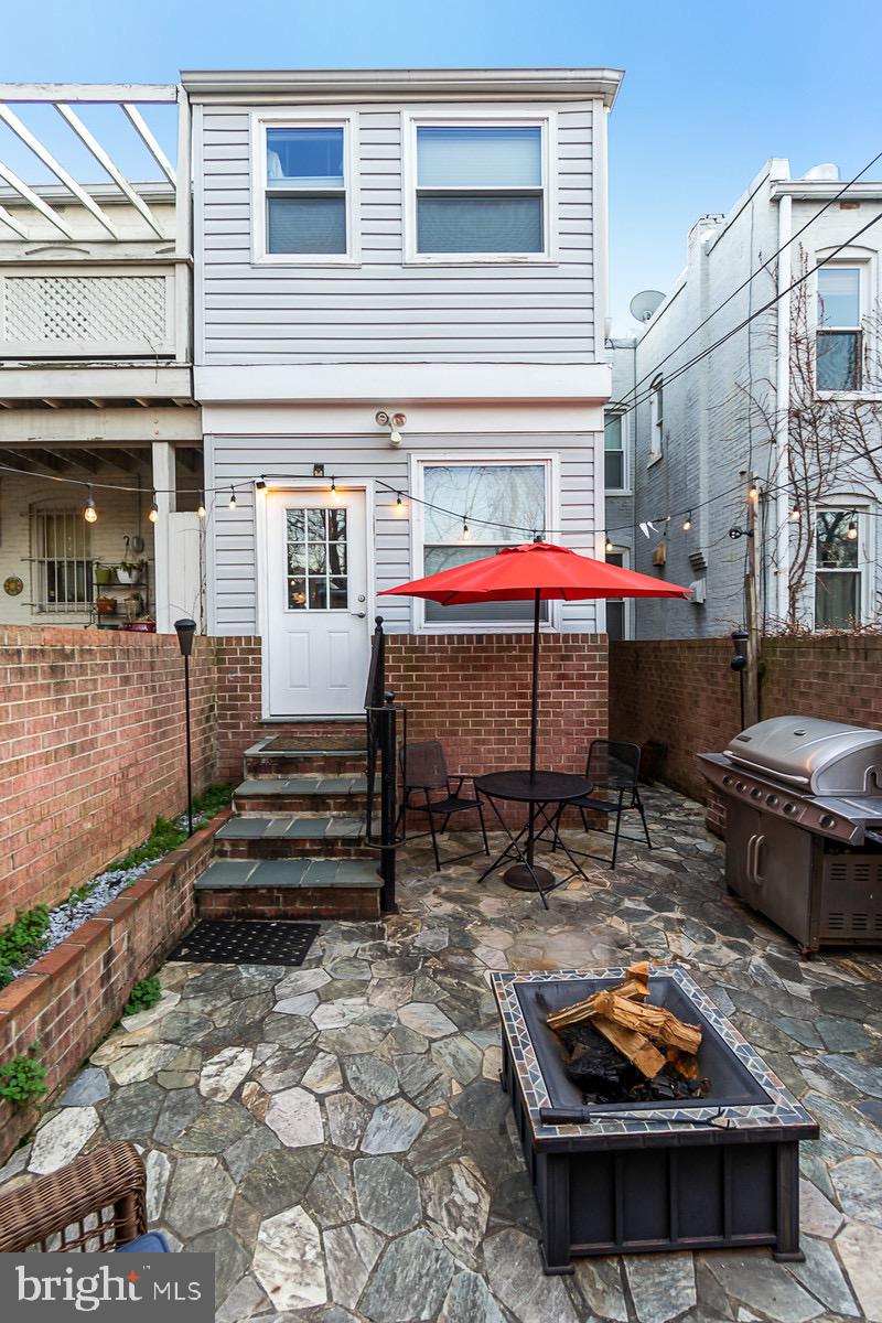1016 G Street Southeast Washington, DC 20003 - Photo 44 of 56 a backyard of a house with barbeque and table and chairs