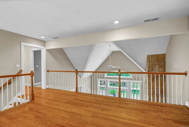 a view of hallway with a large window and wooden floor
