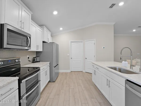 a kitchen with a sink stainless steel appliances and cabinets