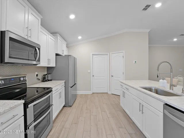 a kitchen with a sink stainless steel appliances and cabinets