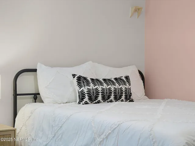 a bedroom with a bed and a night stand