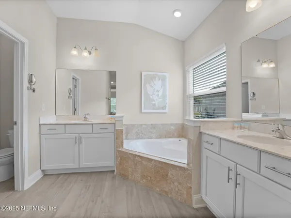 a bathroom with a granite countertop sink mirror and bathtub
