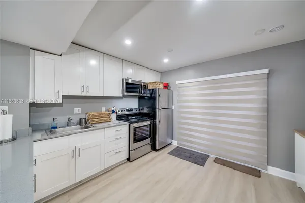 a kitchen with a sink dishwasher a stove and a wooden cabinets