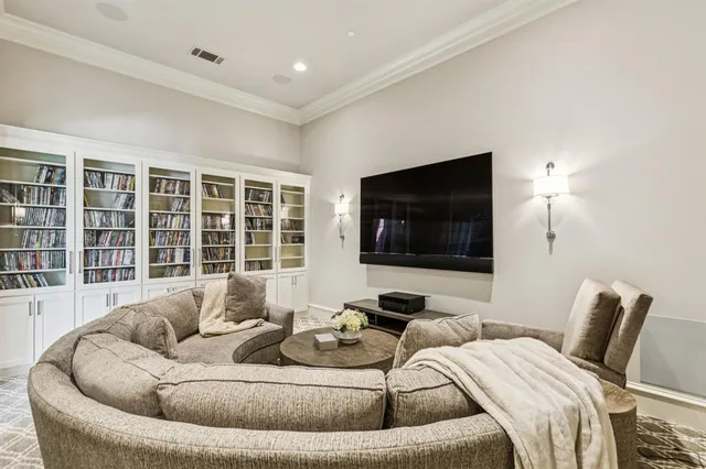 a spacious bedroom with a bed a chandelier and a large window