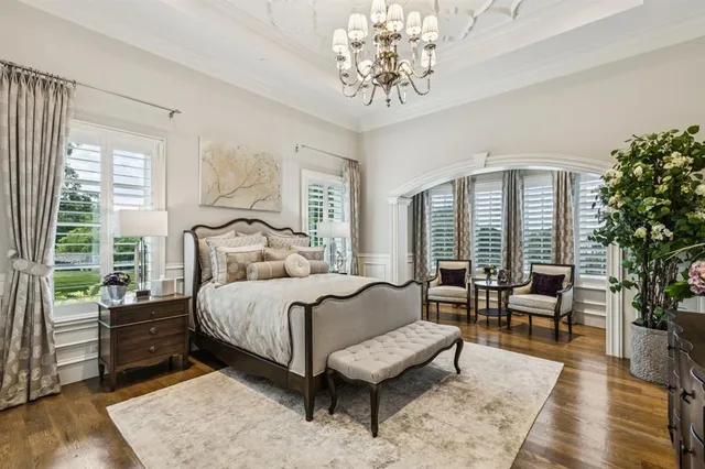 a spacious bedroom with a bed a couch and large windows