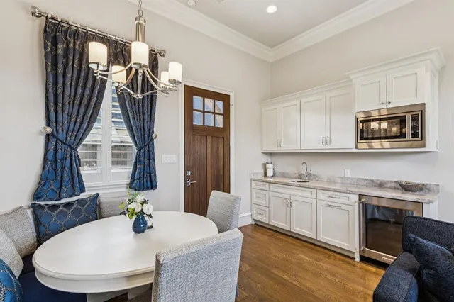 a bedroom with a large bed a chandelier and windows
