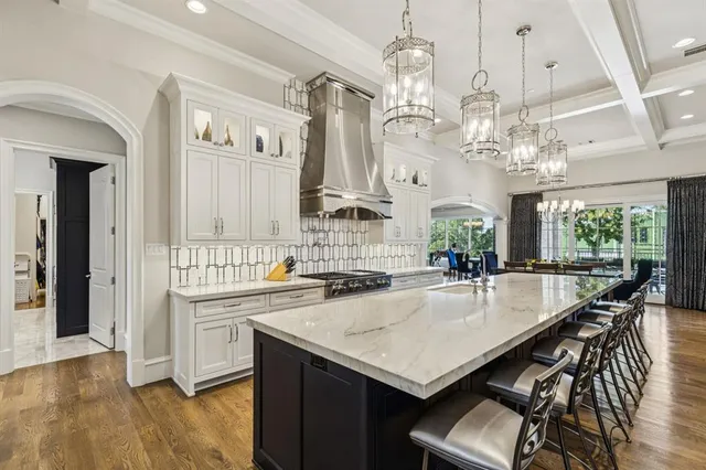 a large kitchen with stainless steel appliances granite countertop a large stove a sink dishwasher and a refrigerator with white cabinets