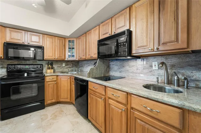 a kitchen with stainless steel appliances granite countertop a stove sink microwave and refrigerator