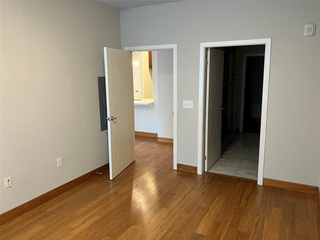 1220 West Trinity Mills Road, Unit 5009 Carrollton, TX 75006 - Photo 6 of 25 an empty room with wooden floor & closet and windows