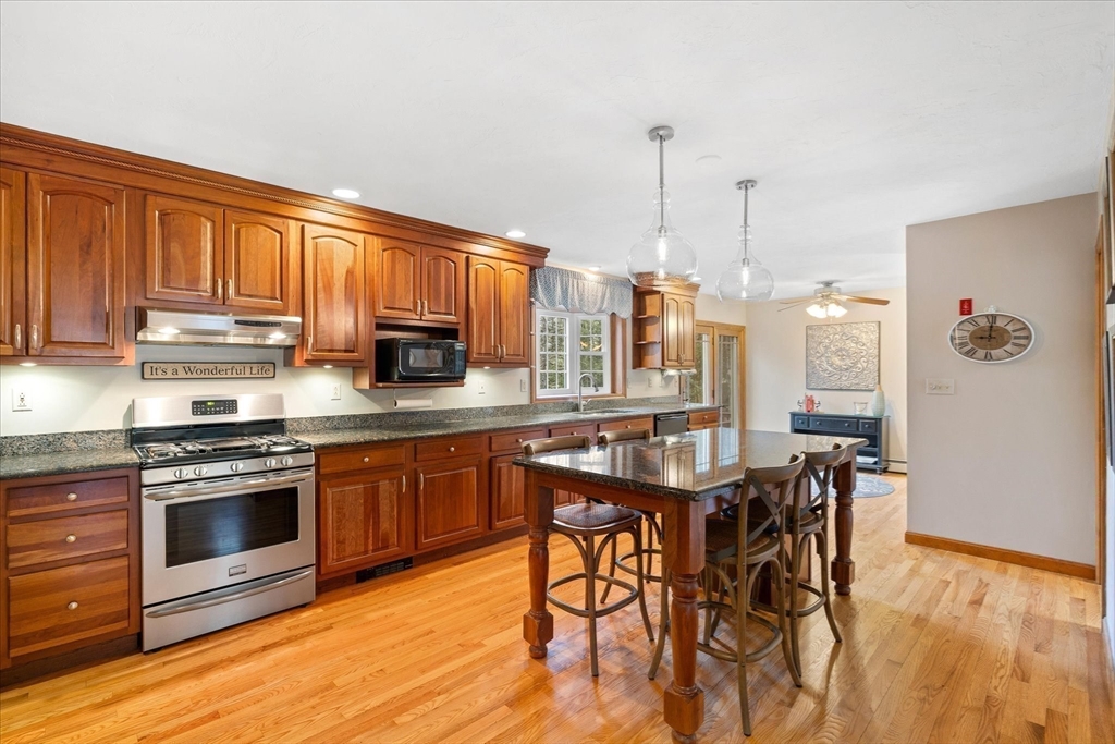33 Glendale Road Sturbridge, MA 01518 - Photo 4 of 27 a kitchen with stainless steel appliances granite countertop wooden floor a stove a sink dishwasher and cabinets with wooden floor