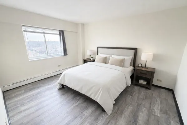 a bedroom with a bed and wooden floor