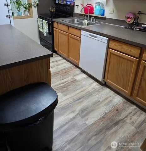 a kitchen with a sink cabinets and wooden floor