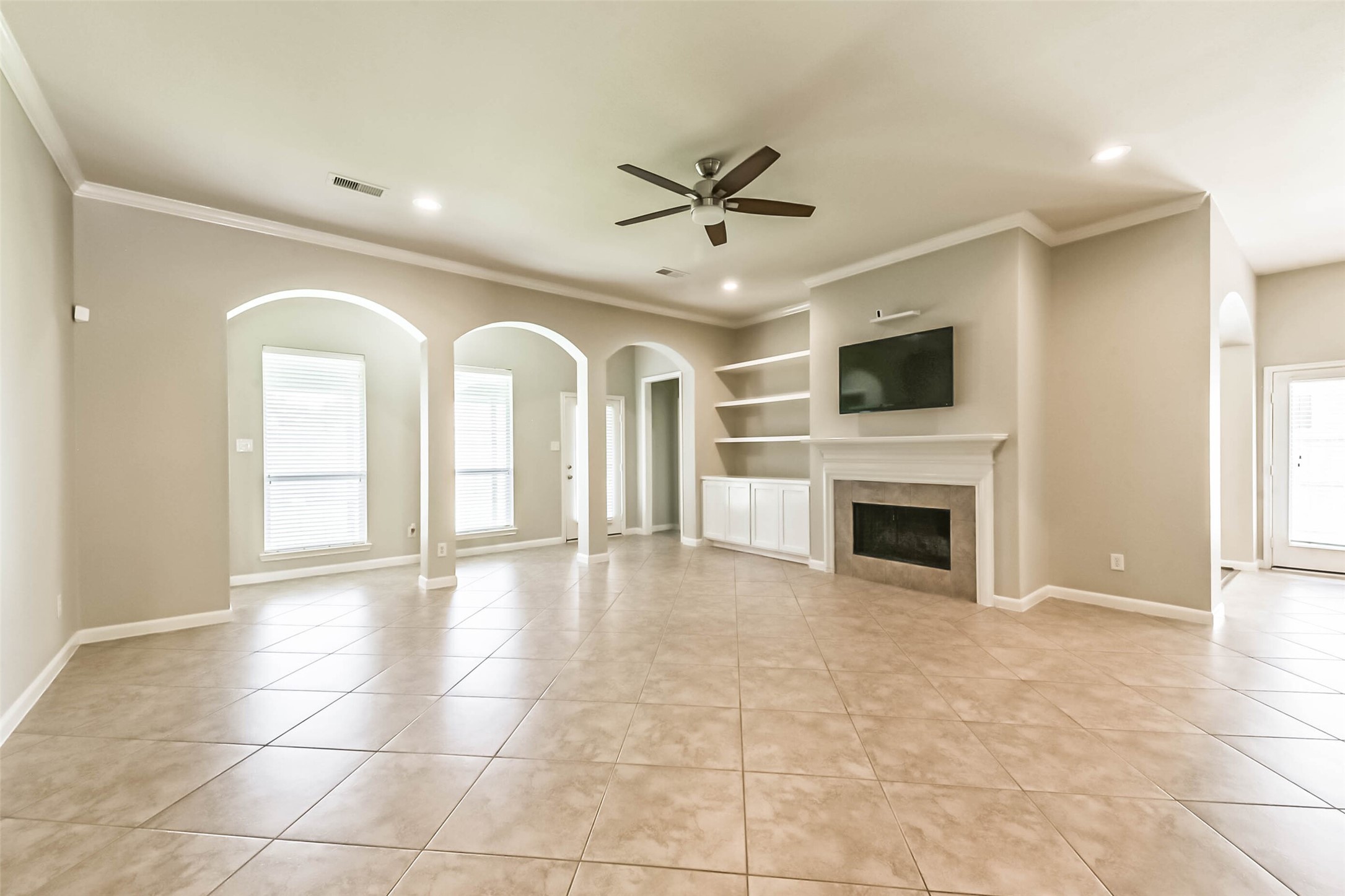 15910 Chart House Court Houston, TX 77044 - Photo 3 of 45 a view of a livingroom with a fireplace a ceiling fan and windows