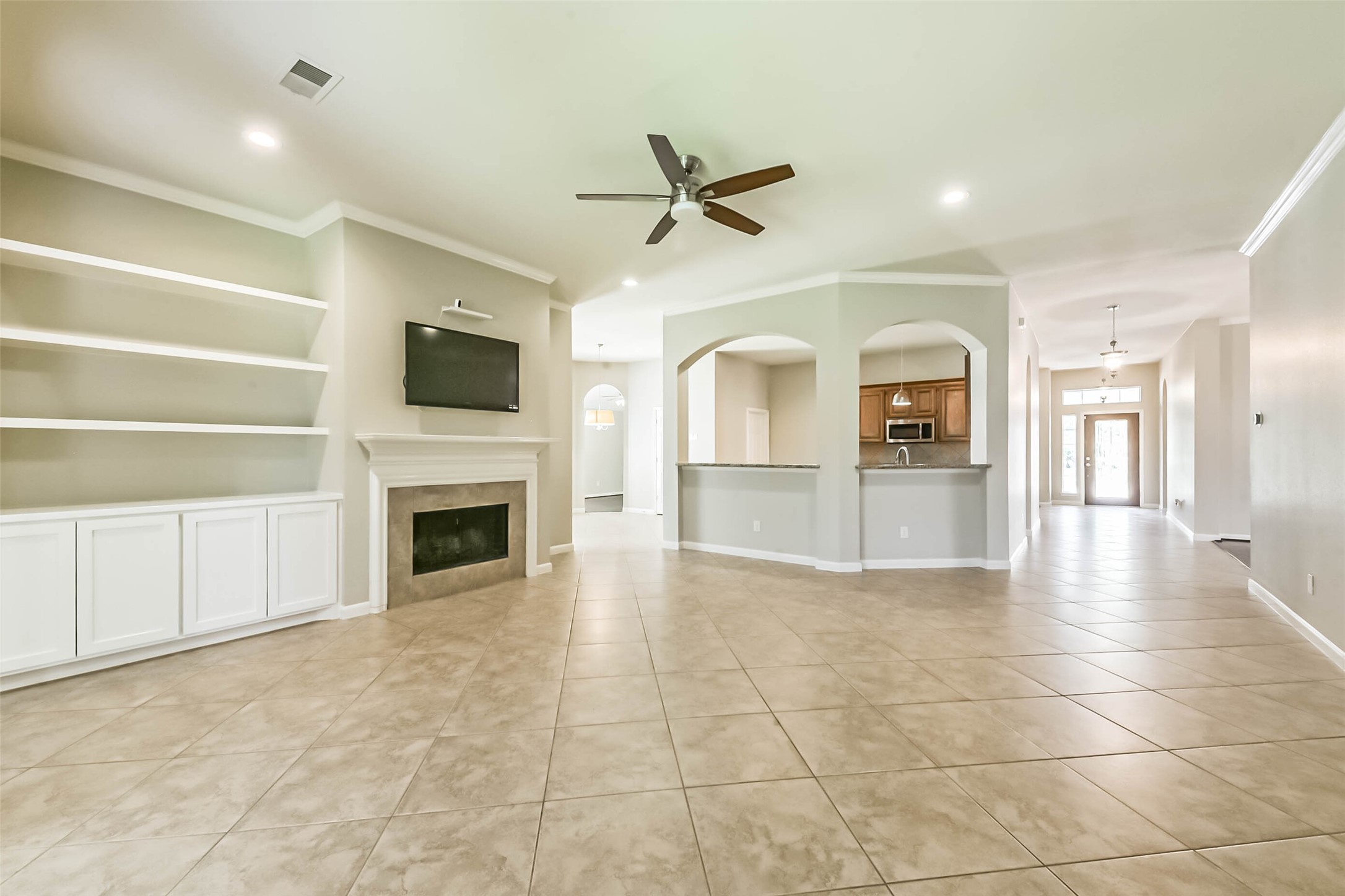 15910 Chart House Court Houston, TX 77044 - Photo 5 of 45 a view of a livingroom with a fireplace a ceiling fan and windows