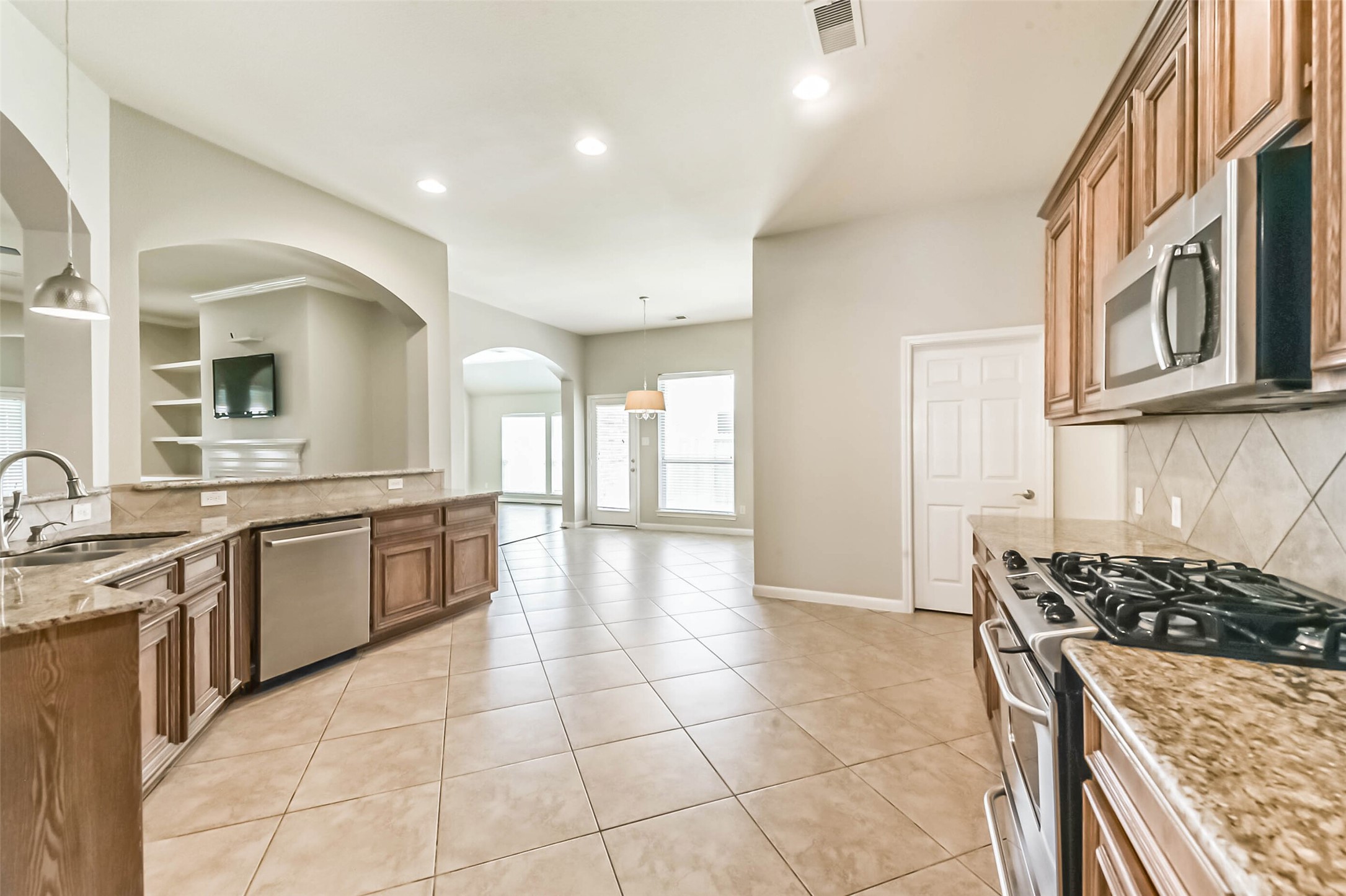 15910 Chart House Court Houston, TX 77044 - Photo 9 of 45 a kitchen with stainless steel appliances granite countertop a stove a sink and a refrigerator