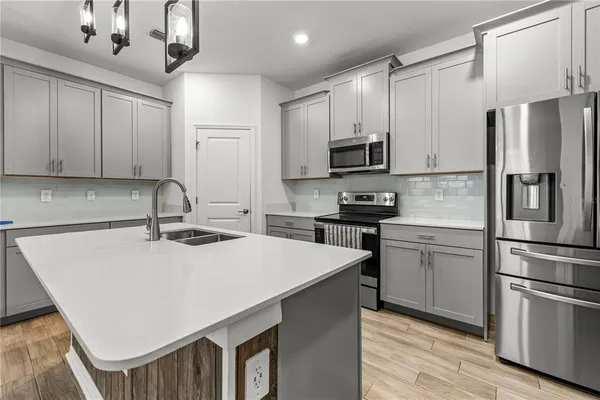 a kitchen with stainless steel appliances a refrigerator sink and microwave