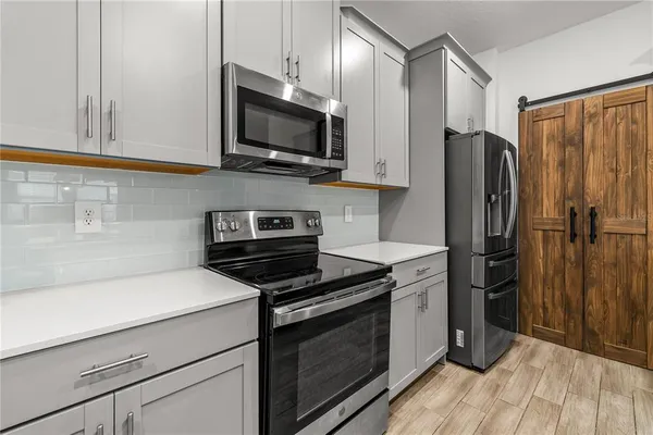 a kitchen with stainless steel appliances a refrigerator stove and microwave