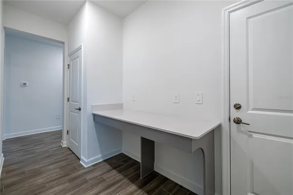 a room with wooden floor and white doors