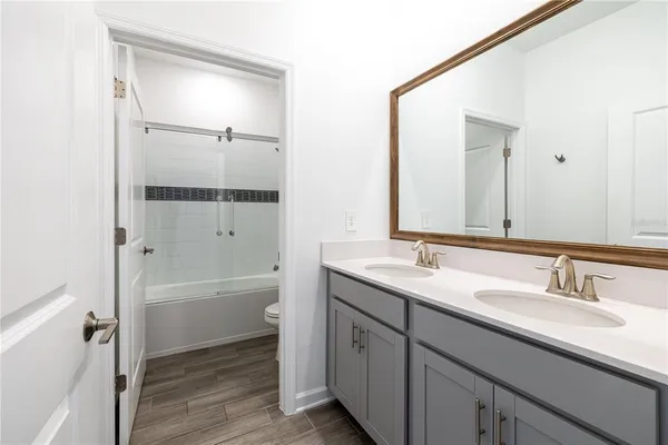 a bathroom with a tub sink double vanity and mirror