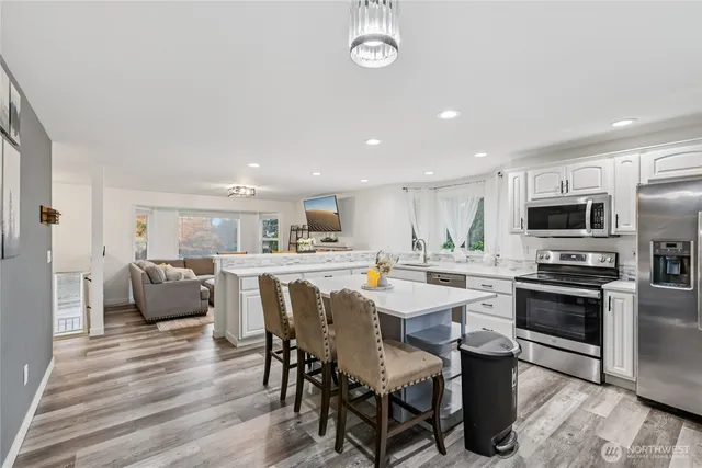 a view of kitchen with microwave stove top oven and cabinets