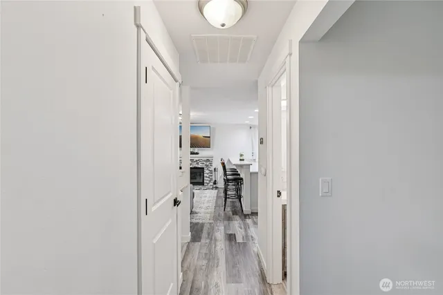 a view of a hallway with wooden floor and a living room