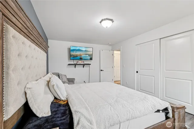 a bedroom with a bed and a flat screen tv