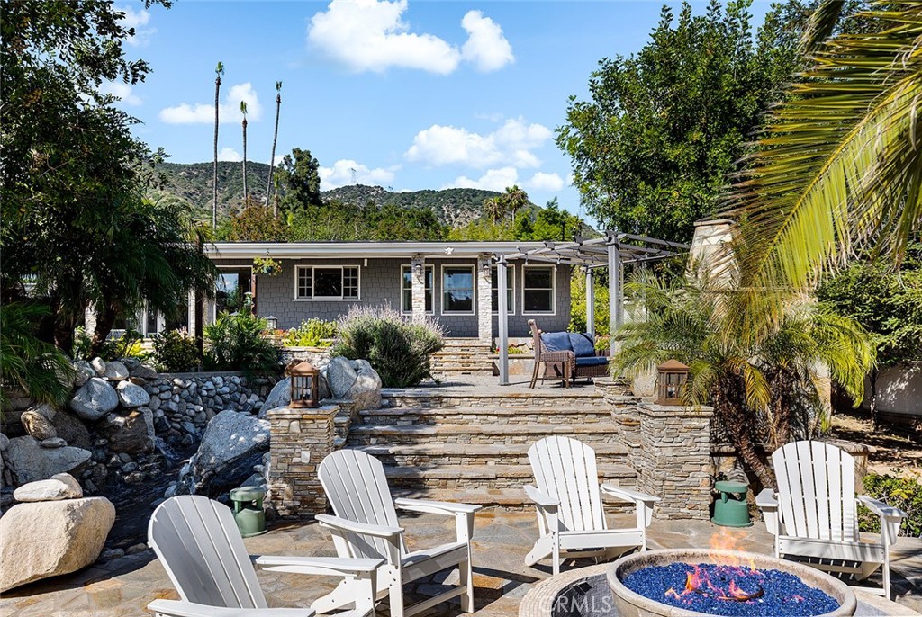 2212 Rim Road Duarte, CA 91008 - Photo 37 of 52 a view of a patio with couches table and chairs potted plants and palm tree