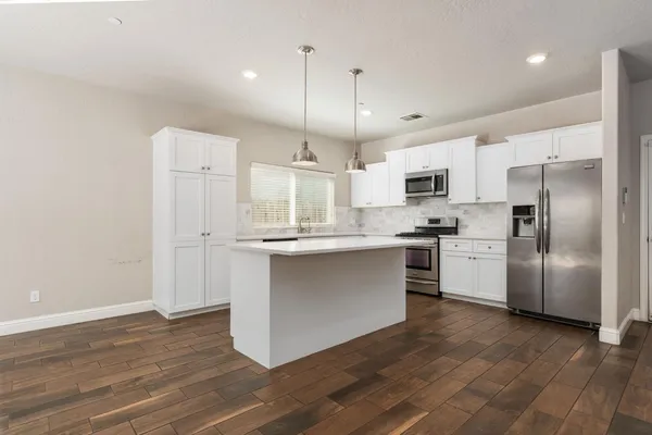 a kitchen with stainless steel appliances a refrigerator sink and microwave