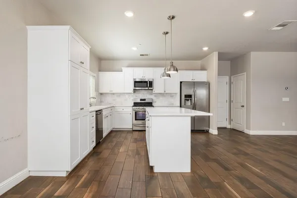 a kitchen with cabinets and wooden floor