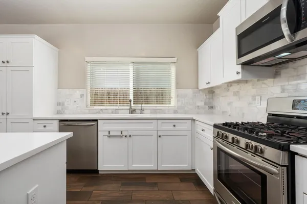 a kitchen with cabinets stainless steel appliances a sink and a stove
