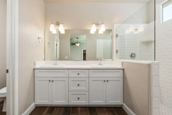 a bathroom with a double vanity sink mirror and shower