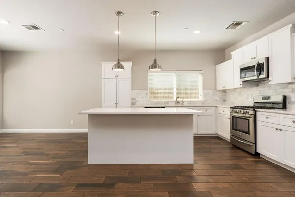 a kitchen with kitchen island a counter top space a sink and appliances