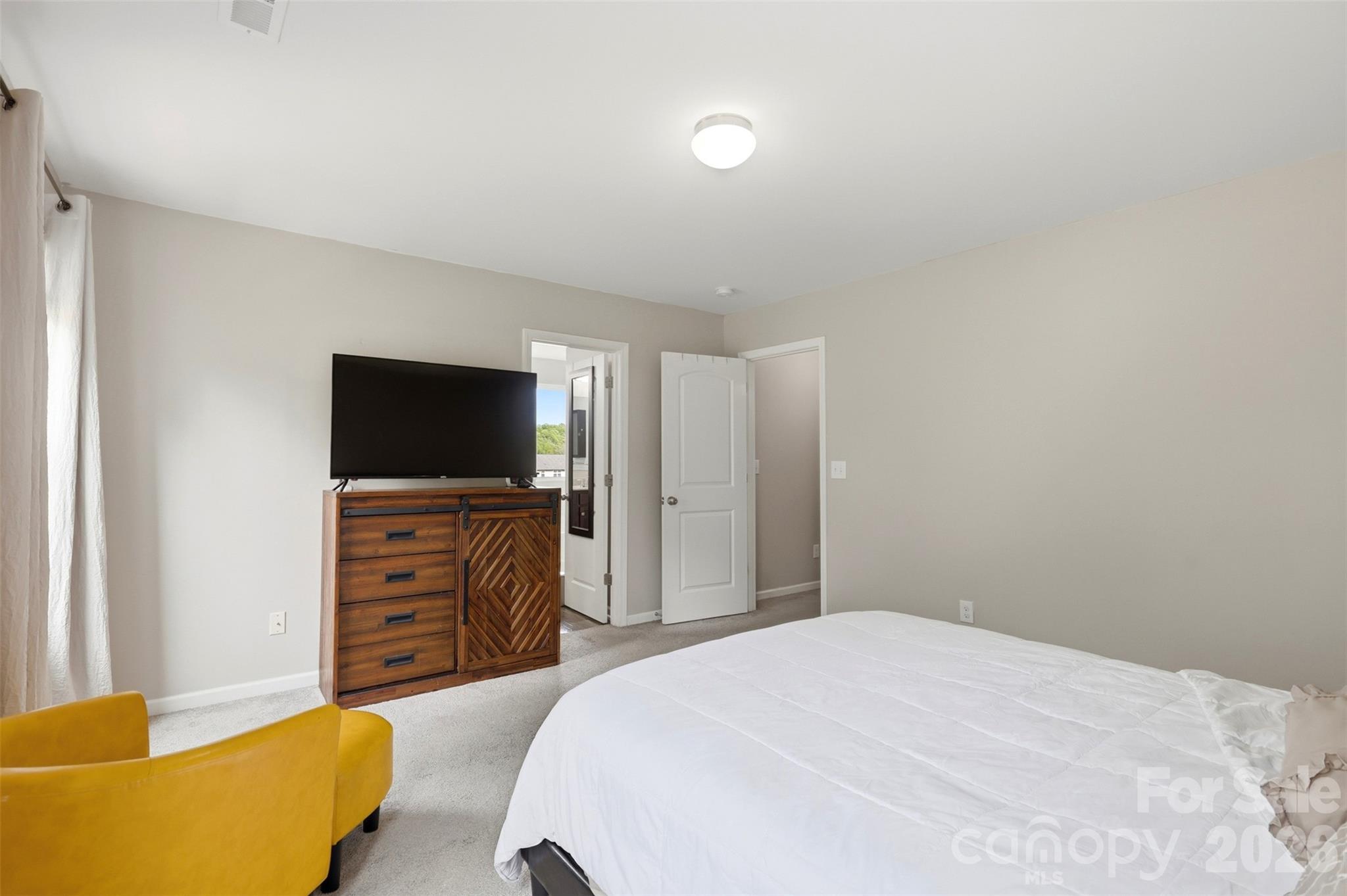 7017 Whitewater Loop Lowell, NC 28098 - Photo 16 of 39 a bedroom with a bed and a flat screen tv