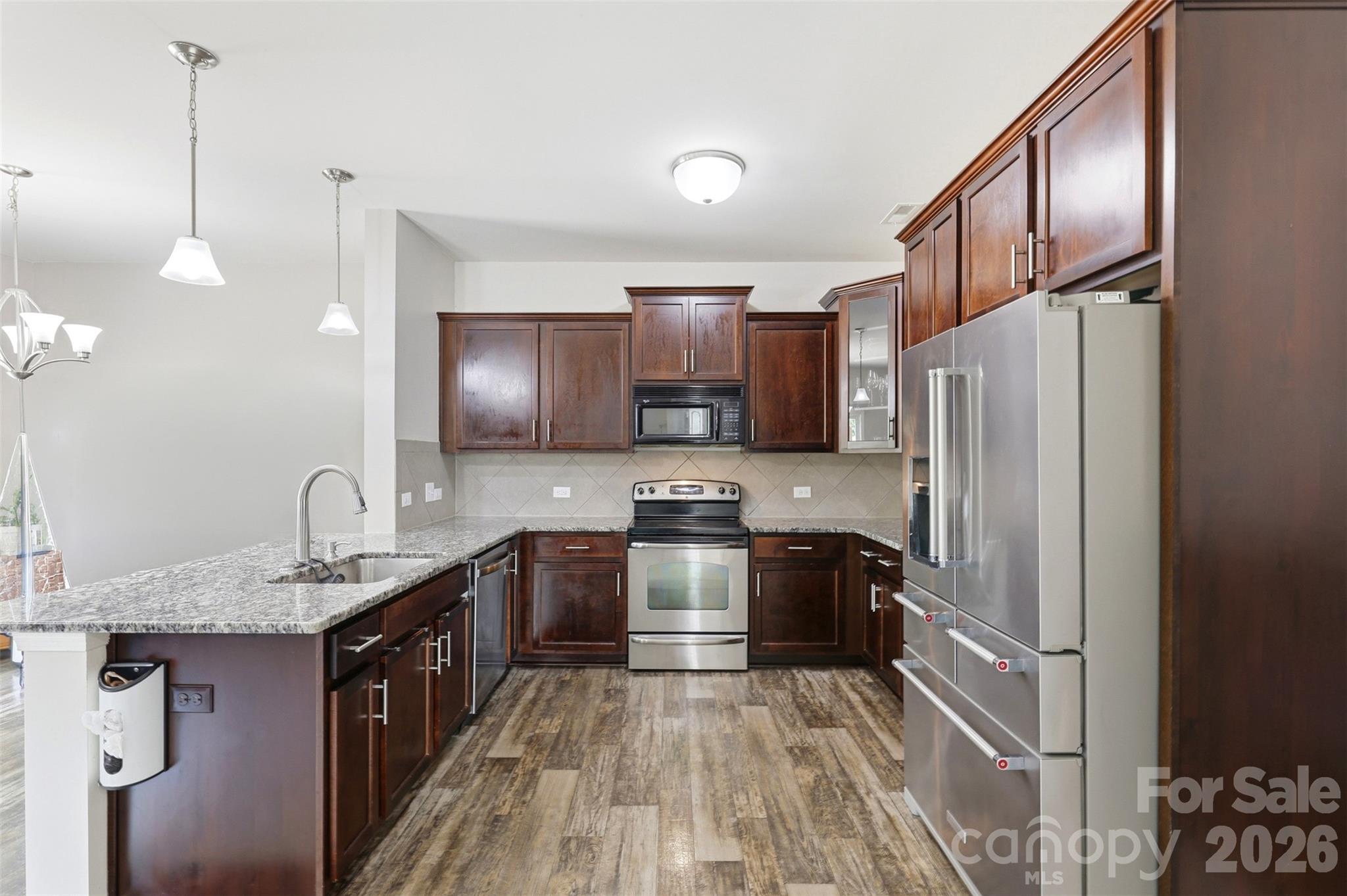 7017 Whitewater Loop Lowell, NC 28098 - Photo 4 of 39 a kitchen with kitchen island granite countertop stainless steel appliances stove a sink and a refrigerator