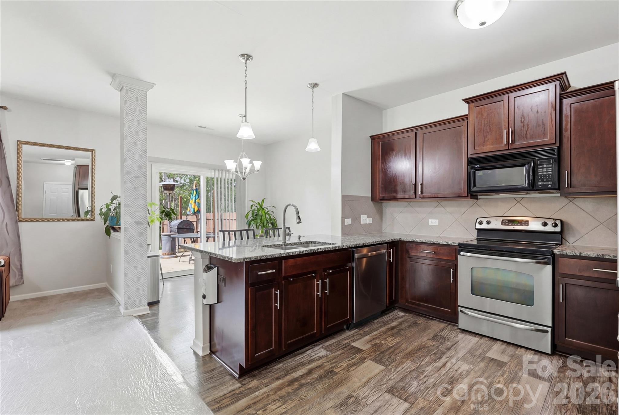7017 Whitewater Loop Lowell, NC 28098 - Photo 6 of 39 a kitchen with stainless steel appliances granite countertop a stove a sink and a refrigerator