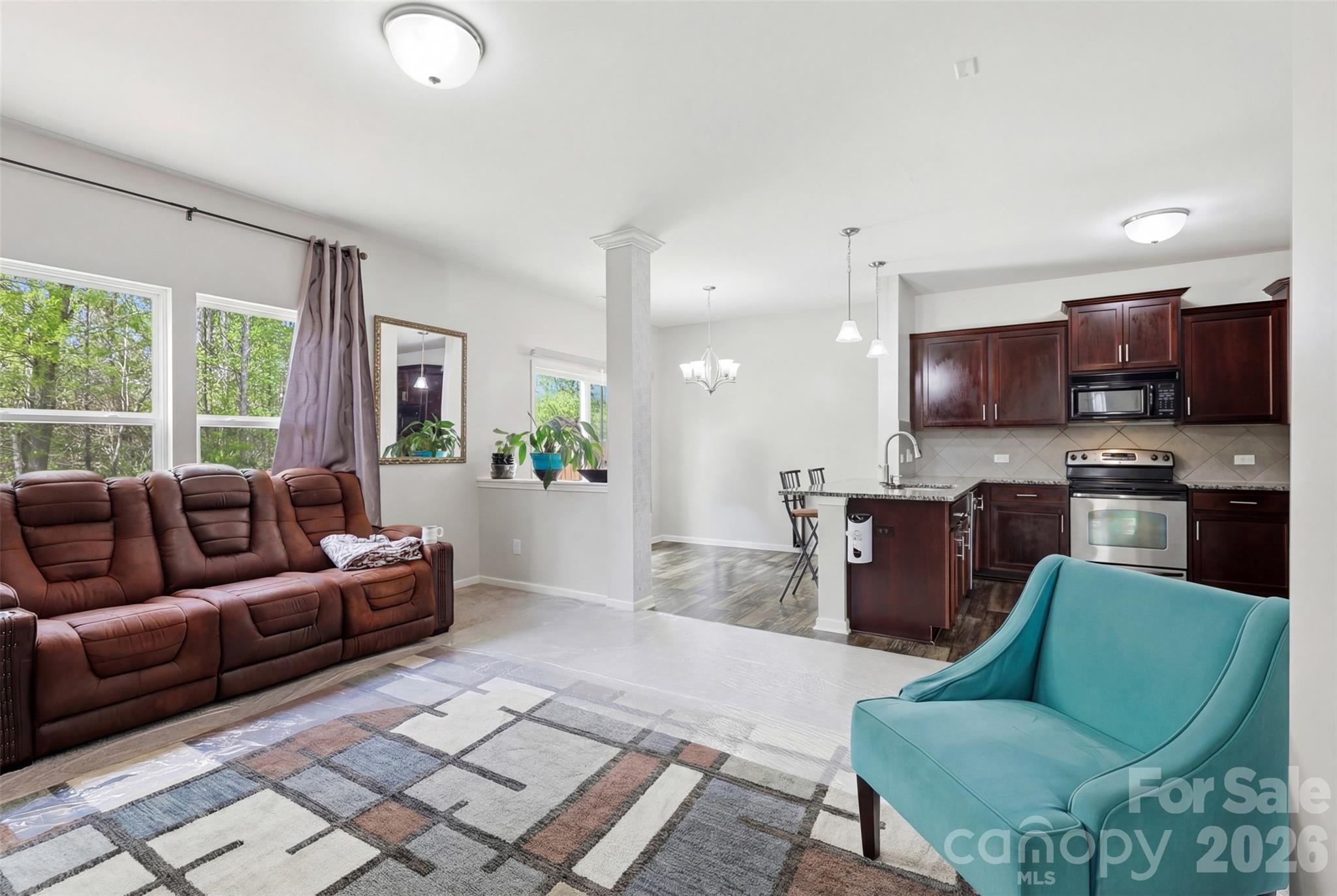 7017 Whitewater Loop Lowell, NC 28098 - Photo 7 of 39 a living room with furniture a large window and a kitchen view