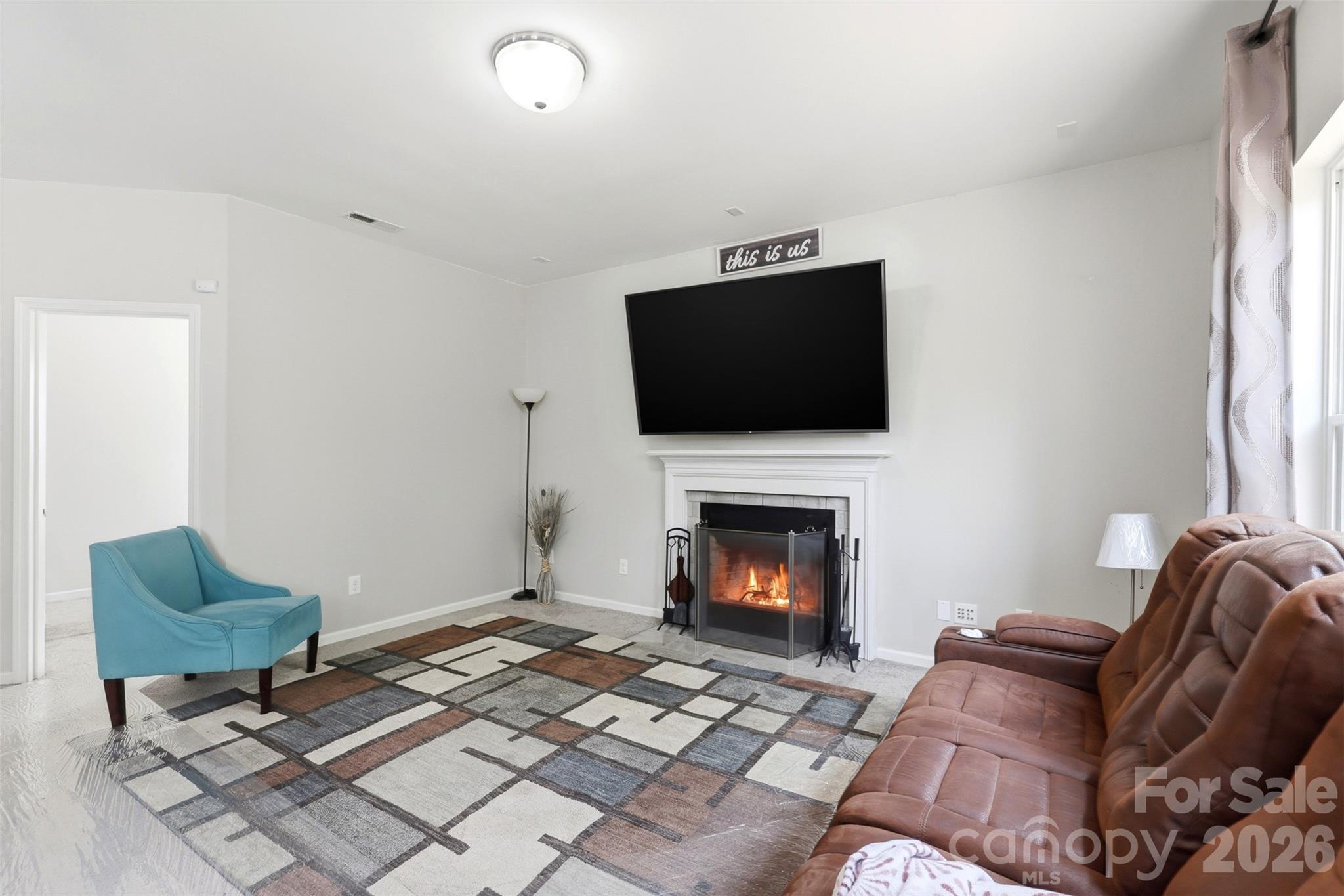 7017 Whitewater Loop Lowell, NC 28098 - Photo 8 of 39 a living room with furniture a flat screen tv and a fireplace