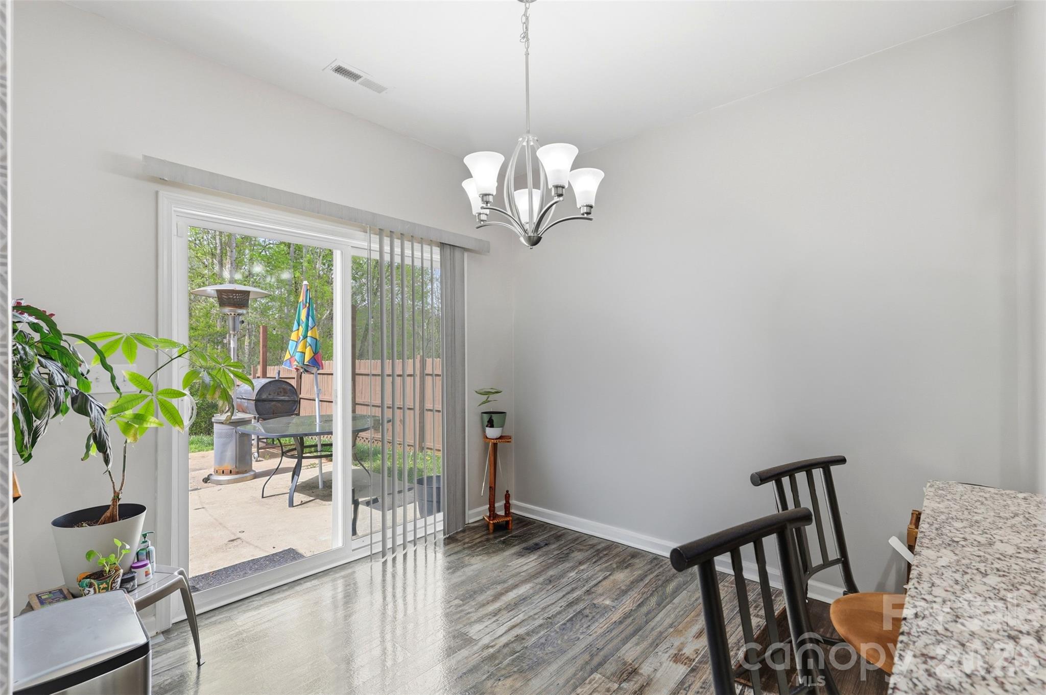 7017 Whitewater Loop Lowell, NC 28098 - Photo 10 of 39 a view of a dining room with furniture a chandelier and wooden floor