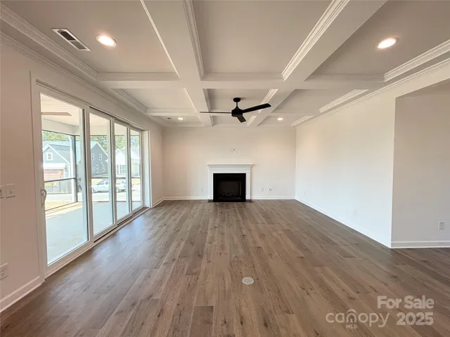 a view of empty room with wooden floor and fireplace