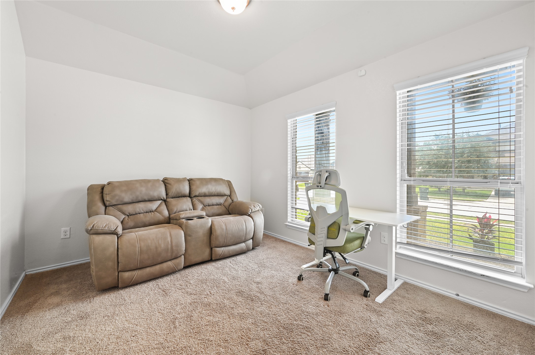 303 Limerick Road Buda, TX 78610 - Photo 10 of 23 Carpeted room with a vaulted ceiling and two windows featuring white blinds