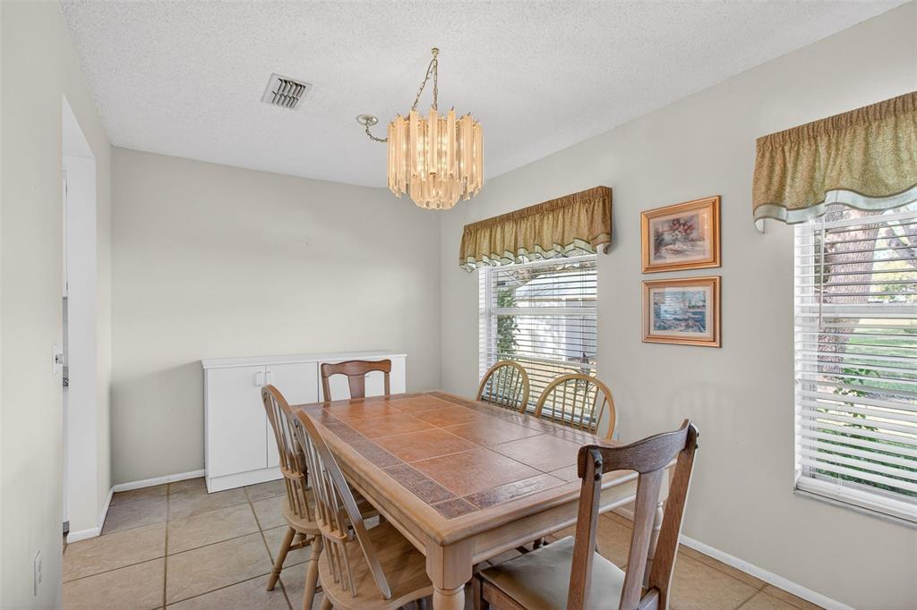 4841 Boonesboro Court New Port Richey, FL 34655 - Photo 11 of 44 a view of a dining room with furniture wooden floor and chandelier