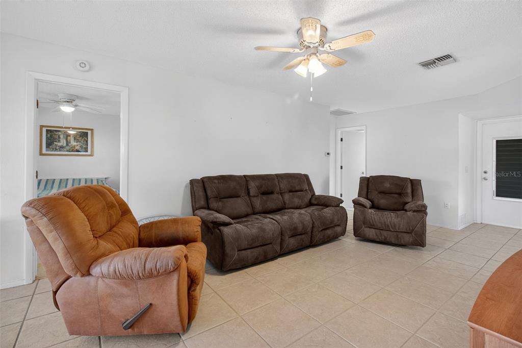 4841 Boonesboro Court New Port Richey, FL 34655 - Photo 13 of 44 a living room with furniture a couch and a chandelier