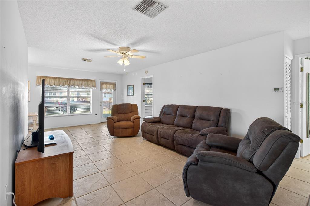 4841 Boonesboro Court New Port Richey, FL 34655 - Photo 15 of 44 a living room with furniture a flat screen tv and a large window