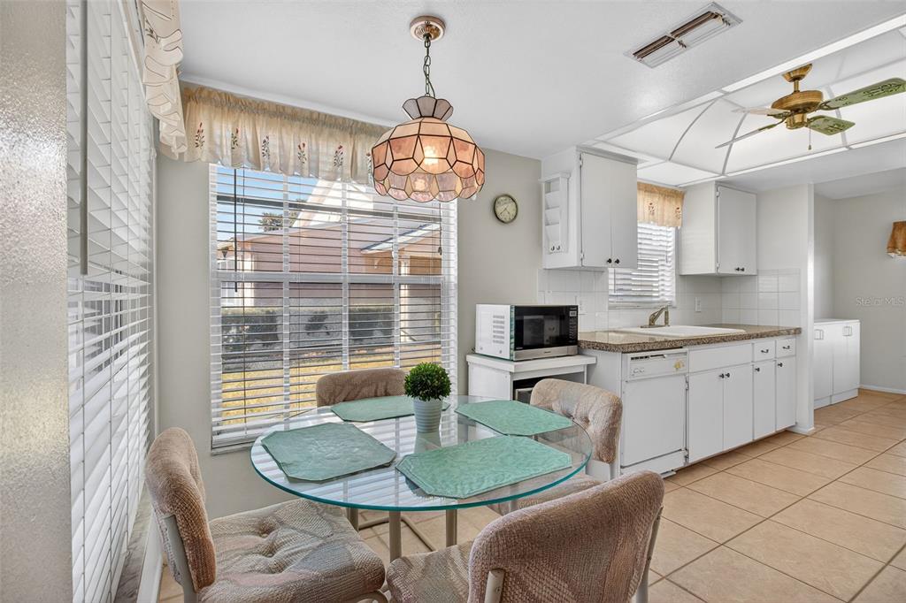 4841 Boonesboro Court New Port Richey, FL 34655 - Photo 6 of 44 a kitchen with a chandelier dining table and chairs