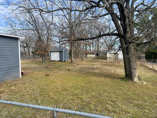 a view of a yard with large trees