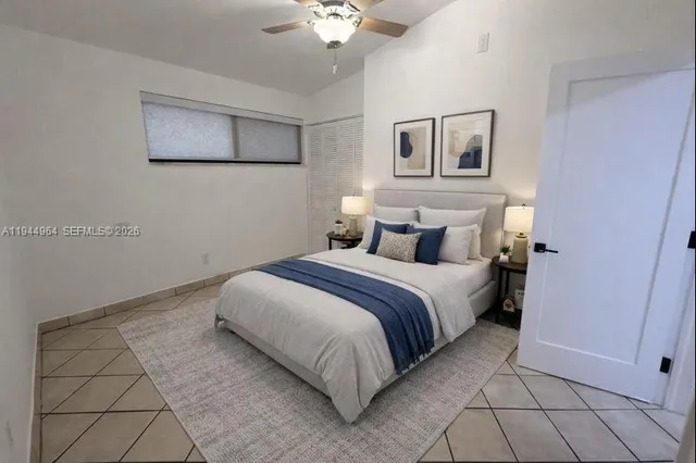 a bedroom with a bed and a ceiling fan