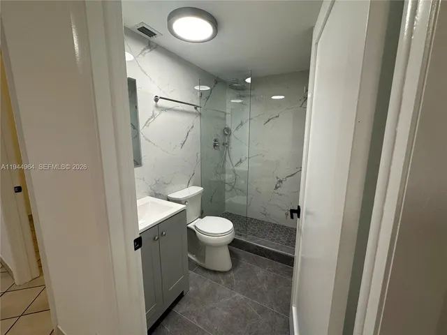 a bathroom with a toilet sink a shower and a mirror